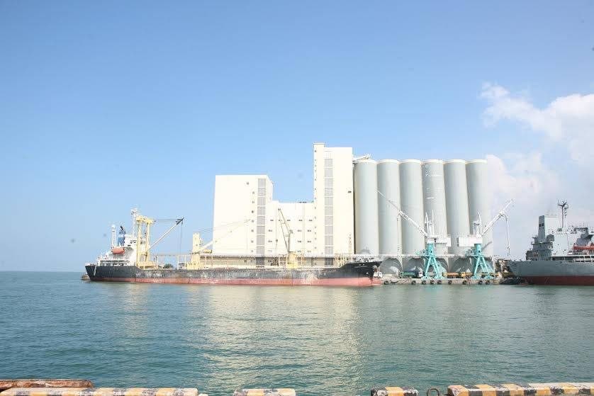 Bulk storage silos and ship loading facilities at a port with vessels alongside